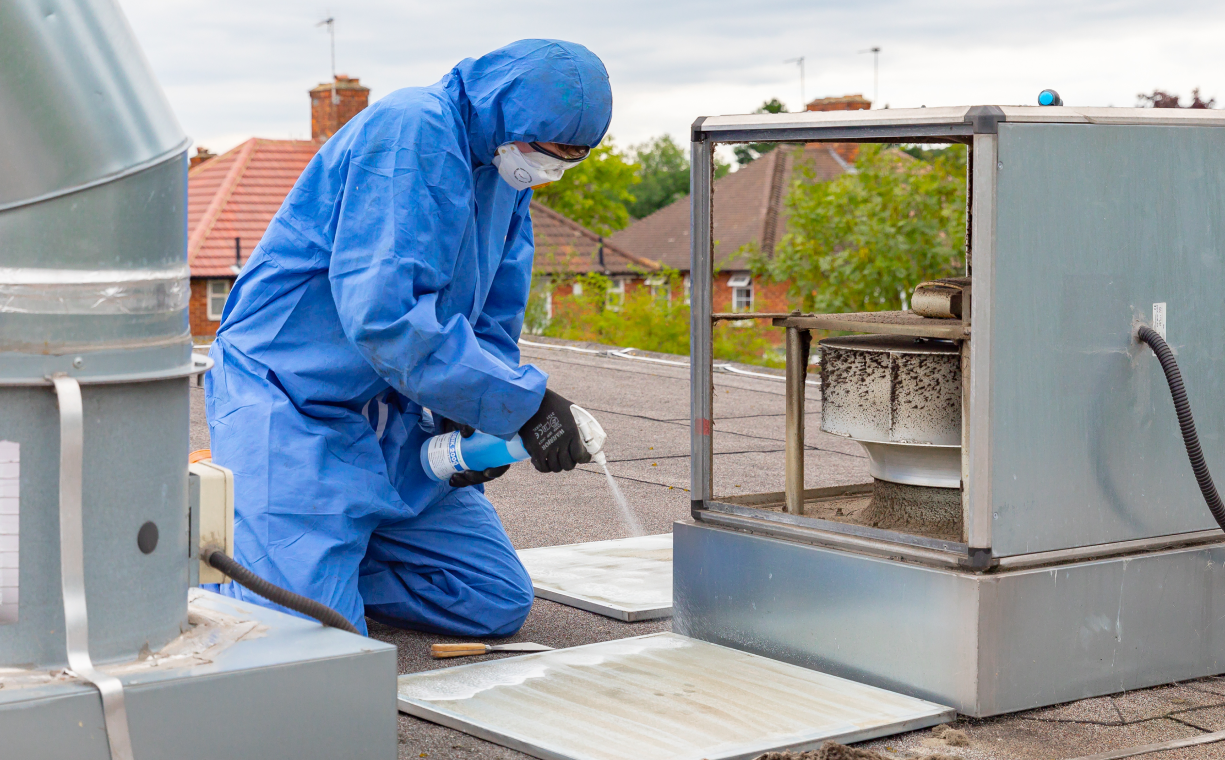 technician doing fan maintenance on top of a roof